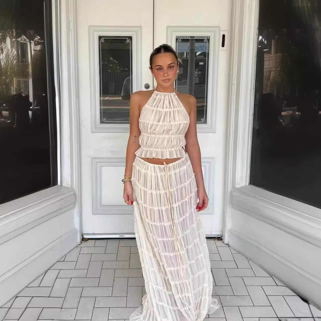 Woman wearing Isla Breeze Two-Piece Set with a high-neck crop top and flowy maxi skirt, perfect for summer beachside outings.