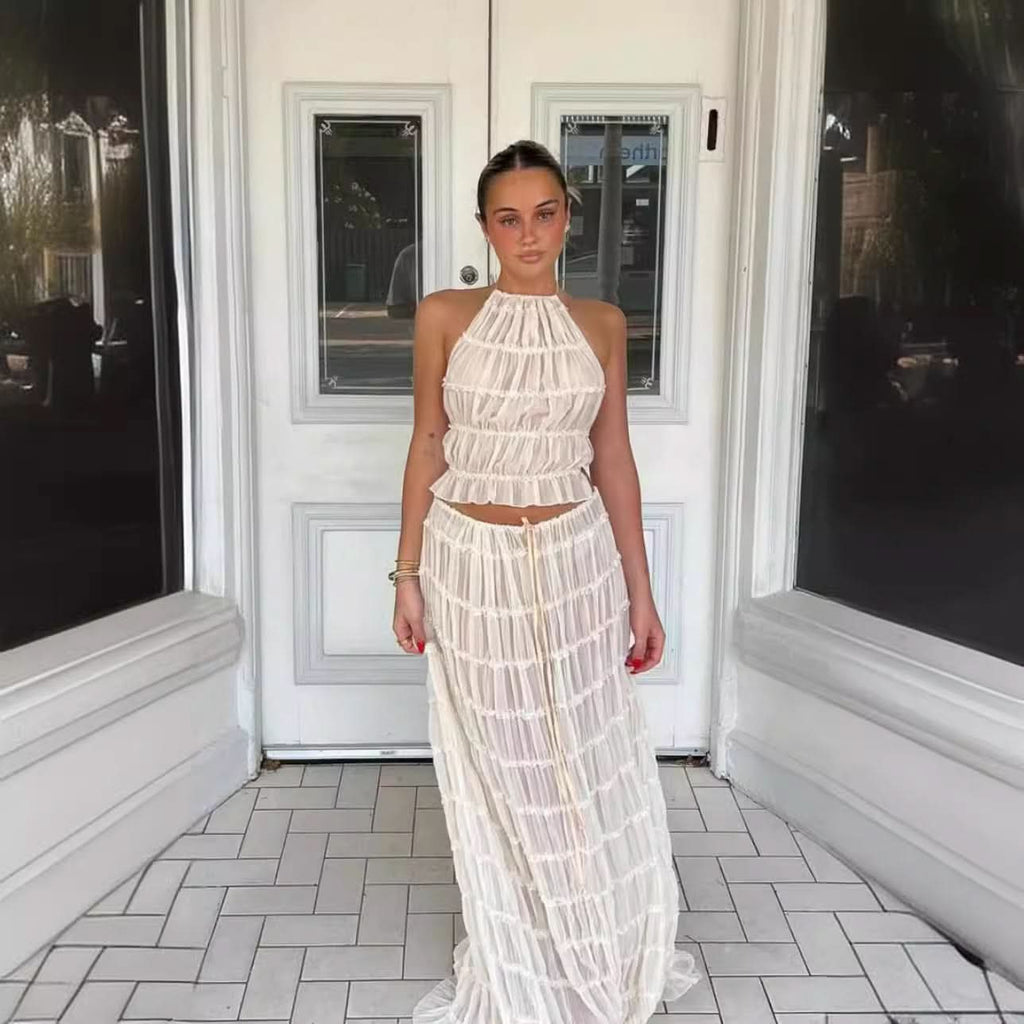 Woman wearing Isla Breeze Two-Piece Set with a high-neck crop top and flowy maxi skirt, perfect for summer beachside outings.