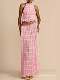 Woman wearing Isla Breeze Two-Piece Set with high-neck crop top and flowy maxi skirt in pink textured crinkle fabric ideal for summer.