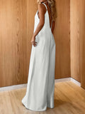 Woman wearing a white Coastal Flow Jumpsuit with a relaxed silhouette, V-neckline, and spaghetti straps, styled for a minimalist, coastal vibe.