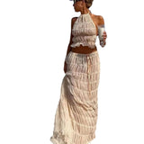 Woman wearing Isla Breeze Two-Piece Set with crinkle fabric crop top and maxi skirt, perfect for beach strolls and summer elegance.