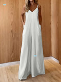 Woman wearing Coastal Flow Jumpsuit, featuring wide-leg style, V-neckline, spaghetti straps, ideal for summer beach and brunch.