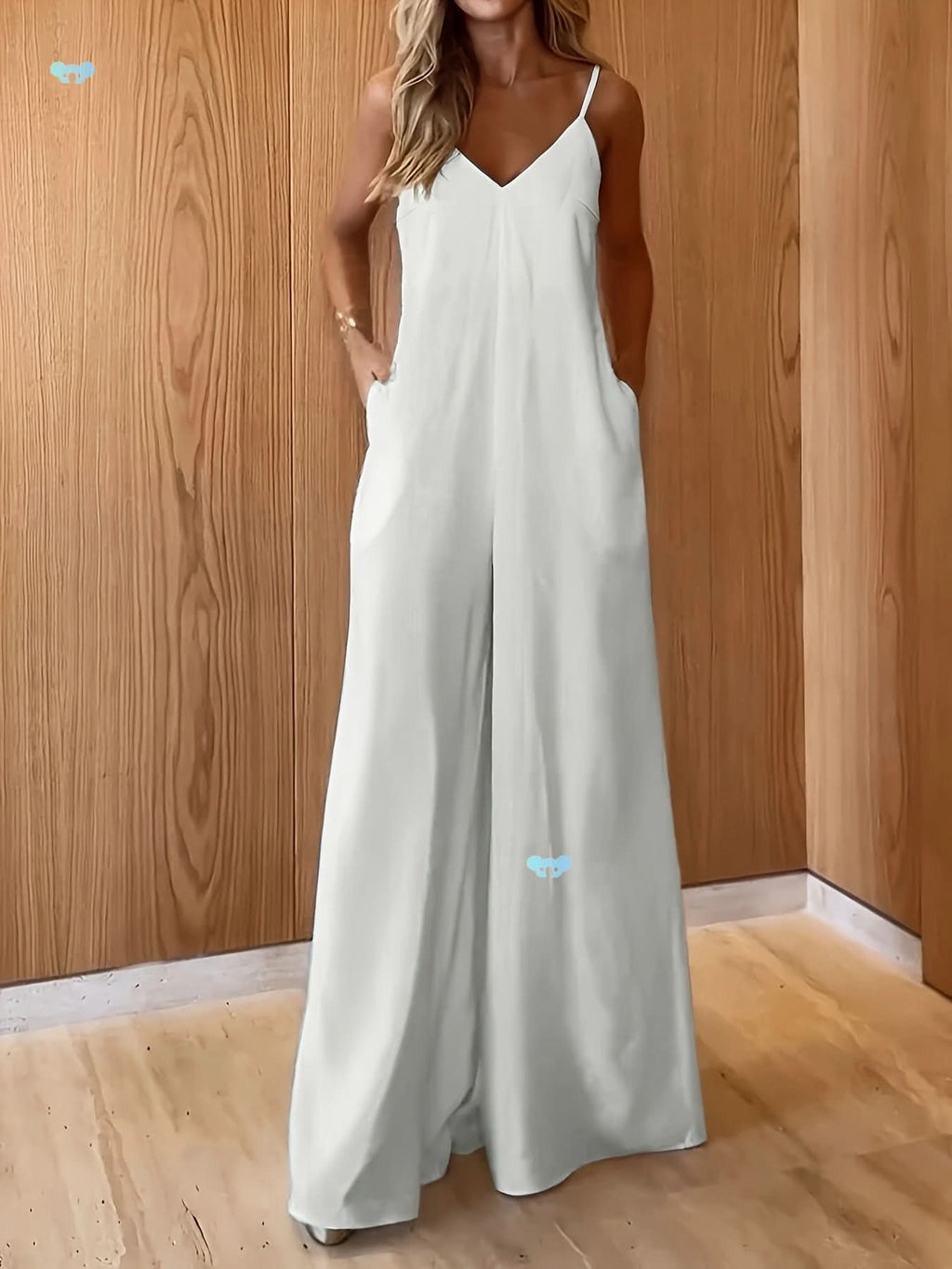 Breezy wide-leg jumpsuit with V-neck and spaghetti straps, perfect for a minimalist coastal vibe. Features soft fabric and side pockets.